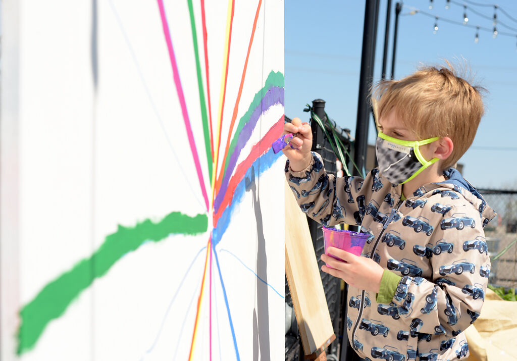 Alex Brownfield helps paint the collaborative mural